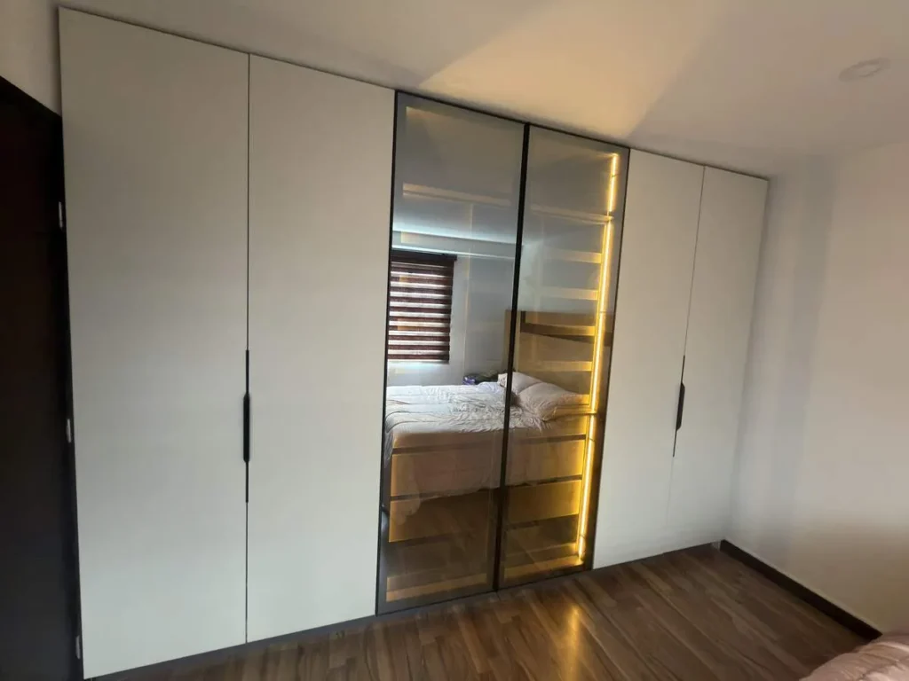 Closet walk-in de melamina blanca con puertas espejadas e iluminación LED cálida - Madertino Bogotá